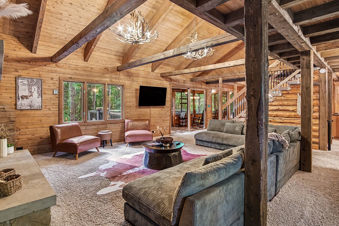 Log cabin lounge area with sectional seating and forest views