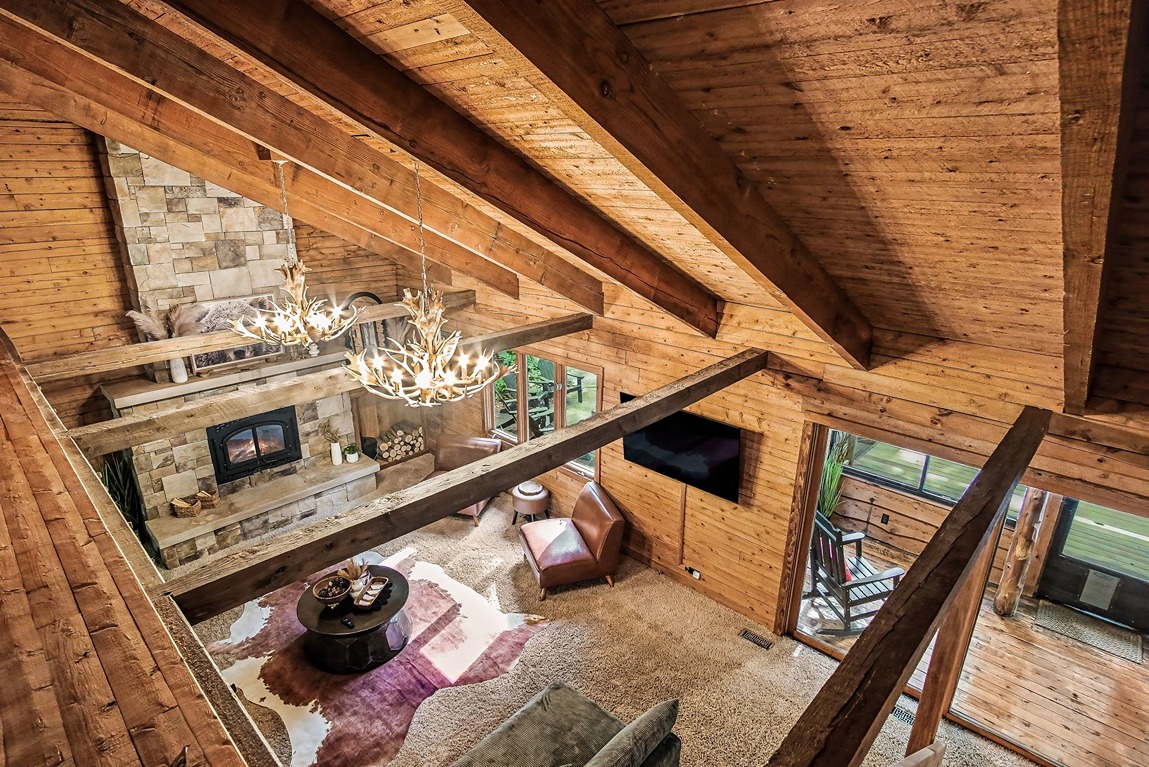 Overhead view of a log cabin living room with vaulted wood ceiling