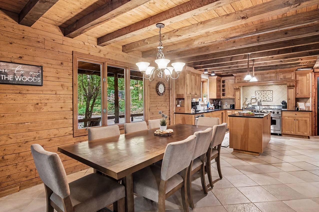 Dining table and kitchen inside a rustic Pine Ridge Retreats cabin