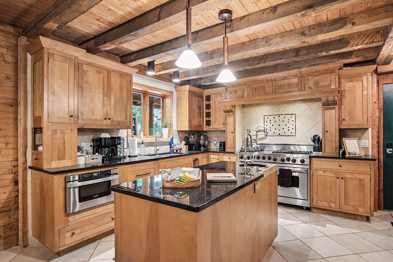 Full kitchen with island and wood cabinetry in a log cabin retreat