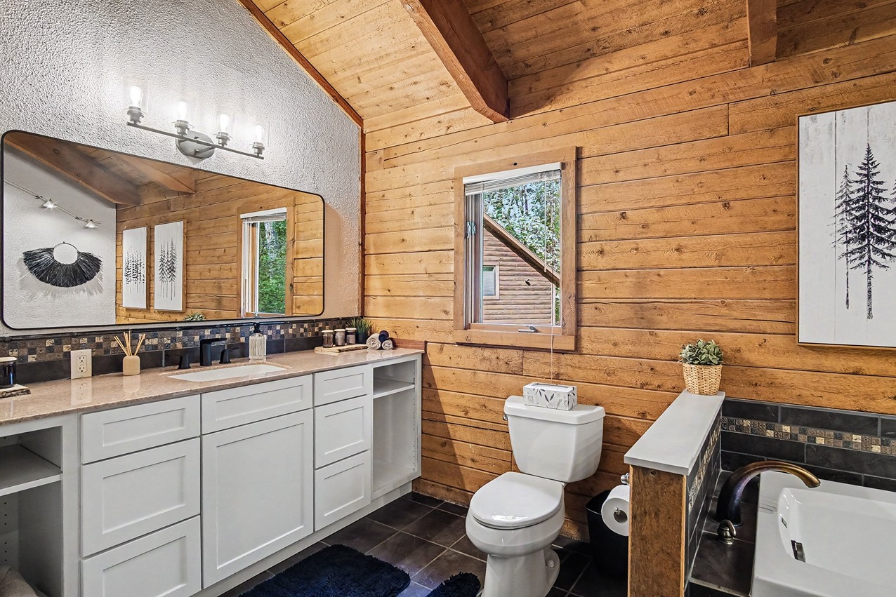 Bathroom vanity with double sinks and wood-paneled walls