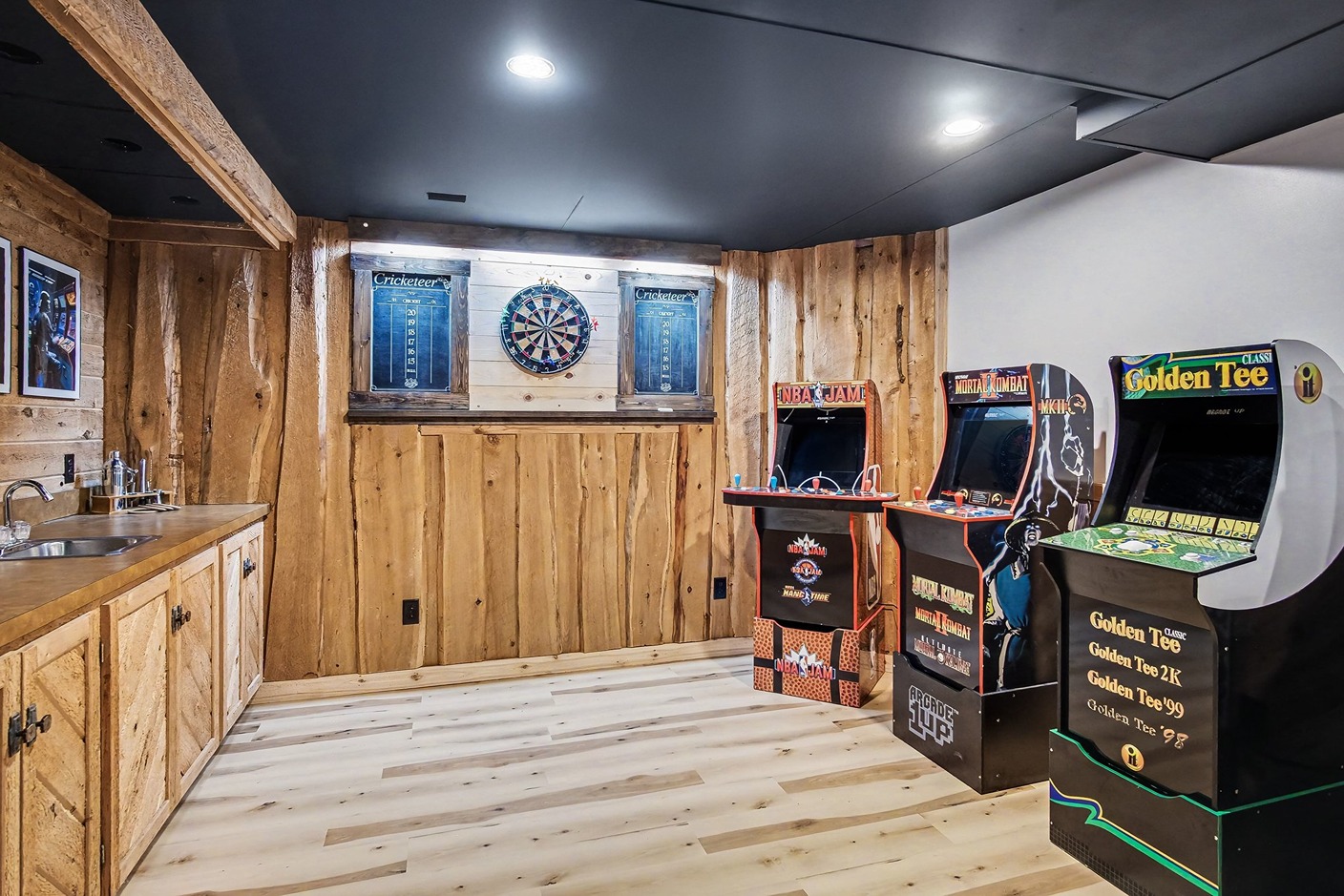 Game room with arcade machines, dartboard, and wood-paneled walls