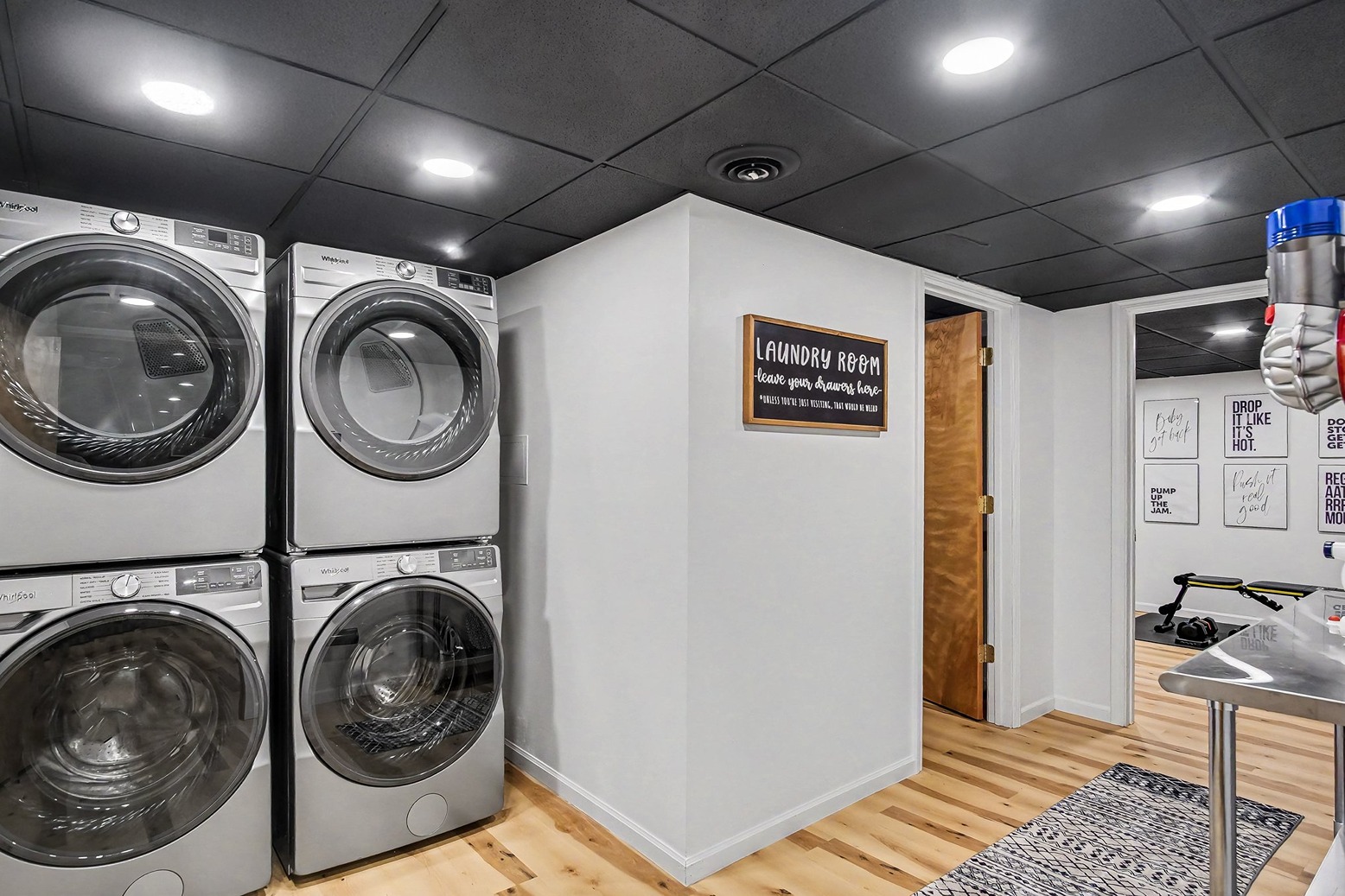 Laundry area with stacked washers and dryers near the exercise room