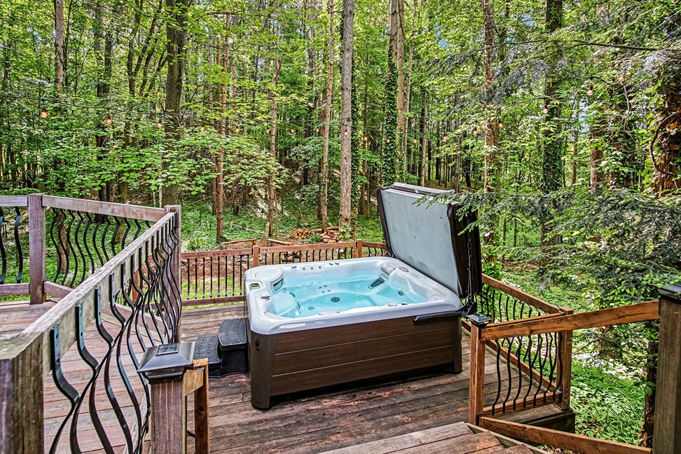 Large deck with dining table and grill at a Pine Ridge Retreats cabin